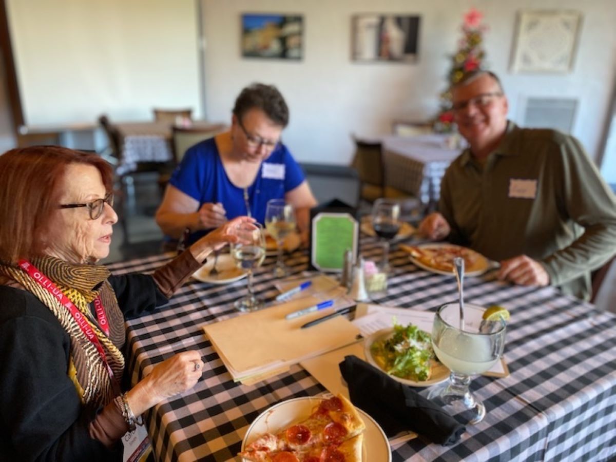 a group of people sitting at a table eating food