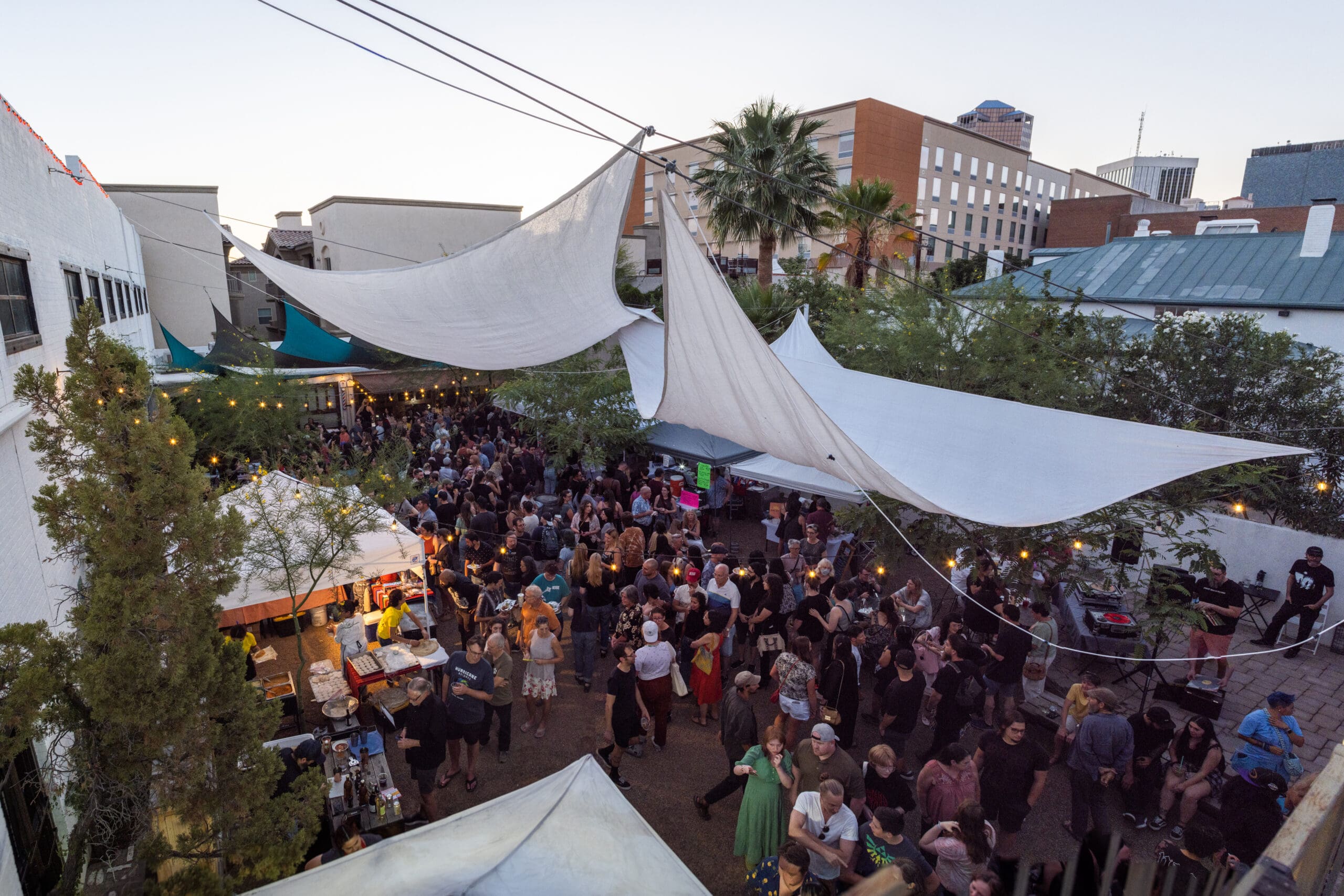 a crowd of people watching a band on stage in front of a building