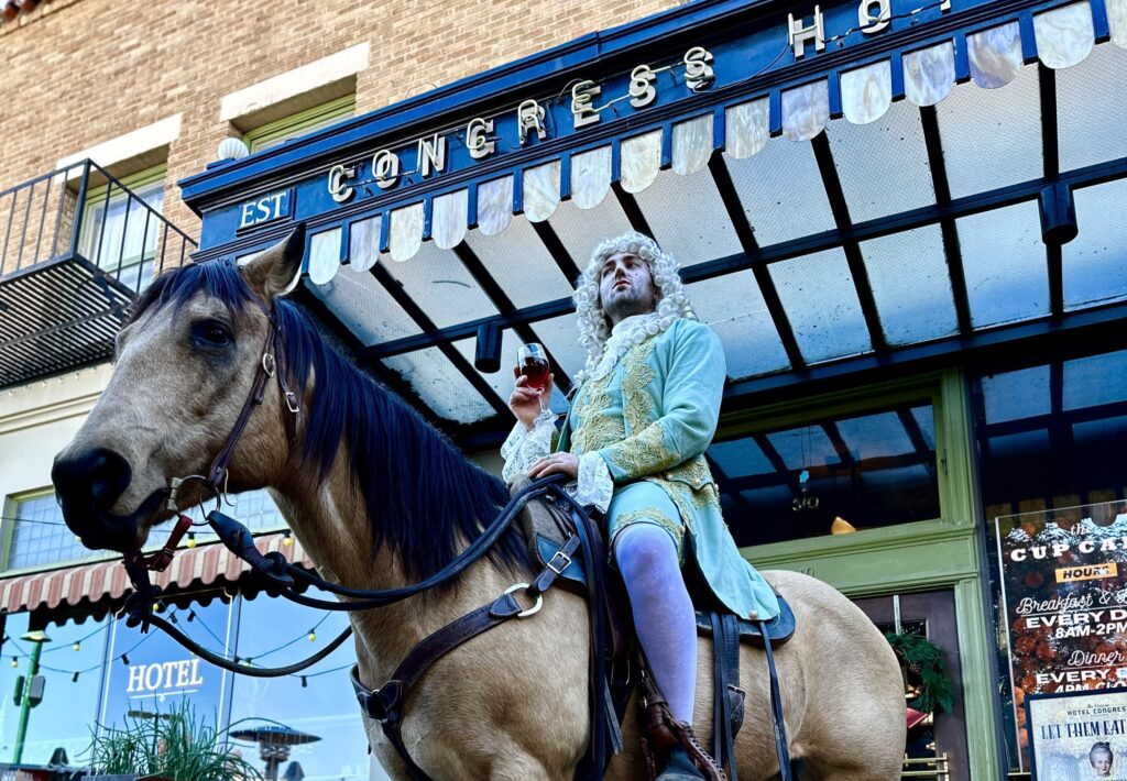 a person riding a horse in front of a building
