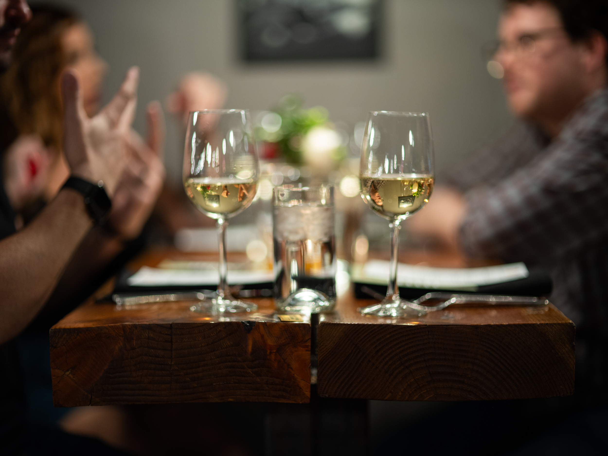 a person sitting at a table with wine glasses