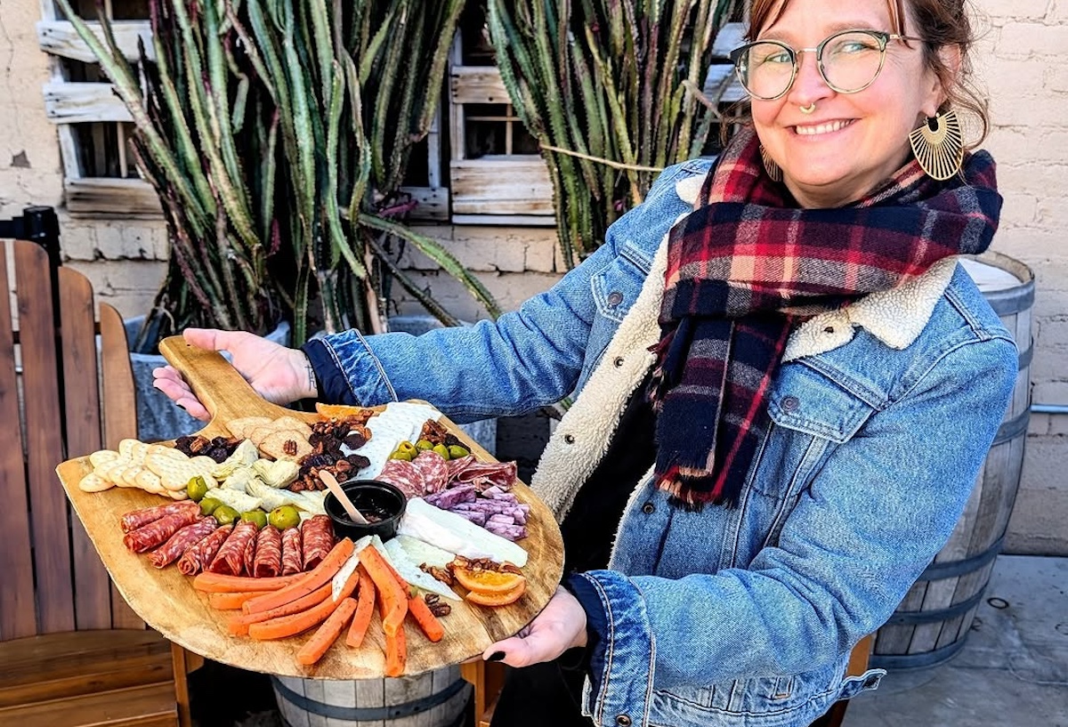 Julie Vernon with a charcuterie board at Crooked Tooth (Photo courtesy of Crooked Tooth Brewing)