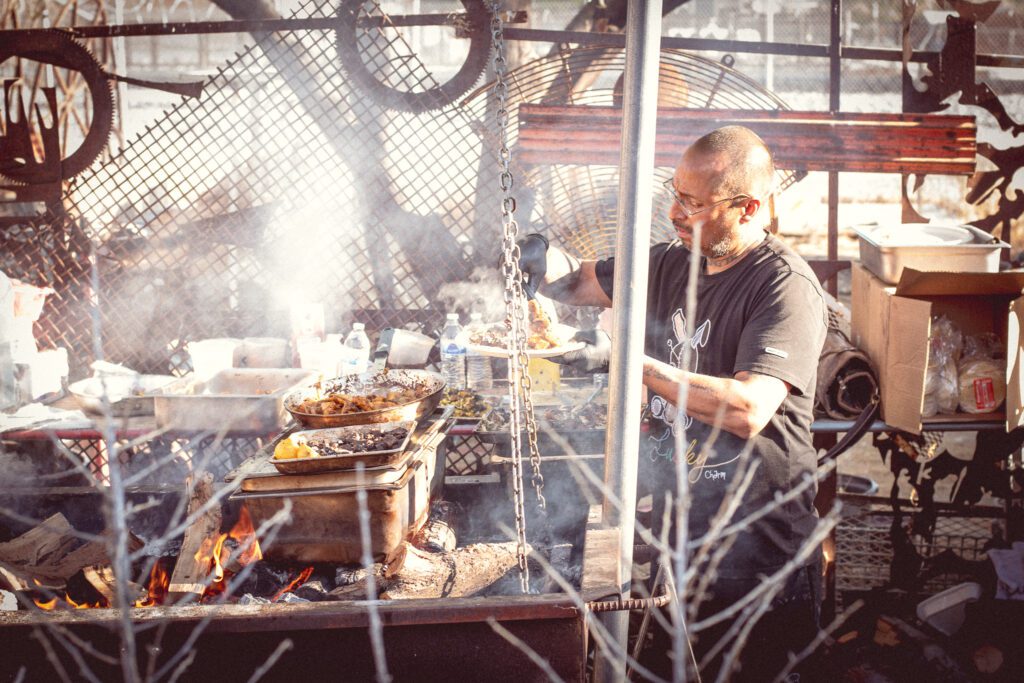 Chef Pablo Valencia cooking over flames at 420 Fest 2025 at Whistle Stop Depot (Photo by Jackie Tran)