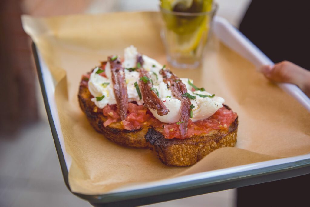 Tomato, burrata, and anchovies on Barrio Bread at La Esquina (Photo by Jackie Tran)