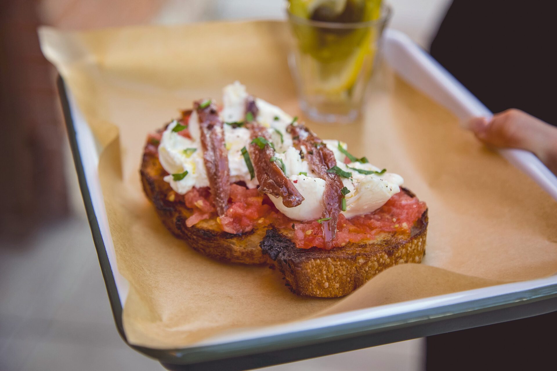 Tomato, burrata, and anchovies on Barrio Bread at La Esquina (Photo by Jackie Tran)